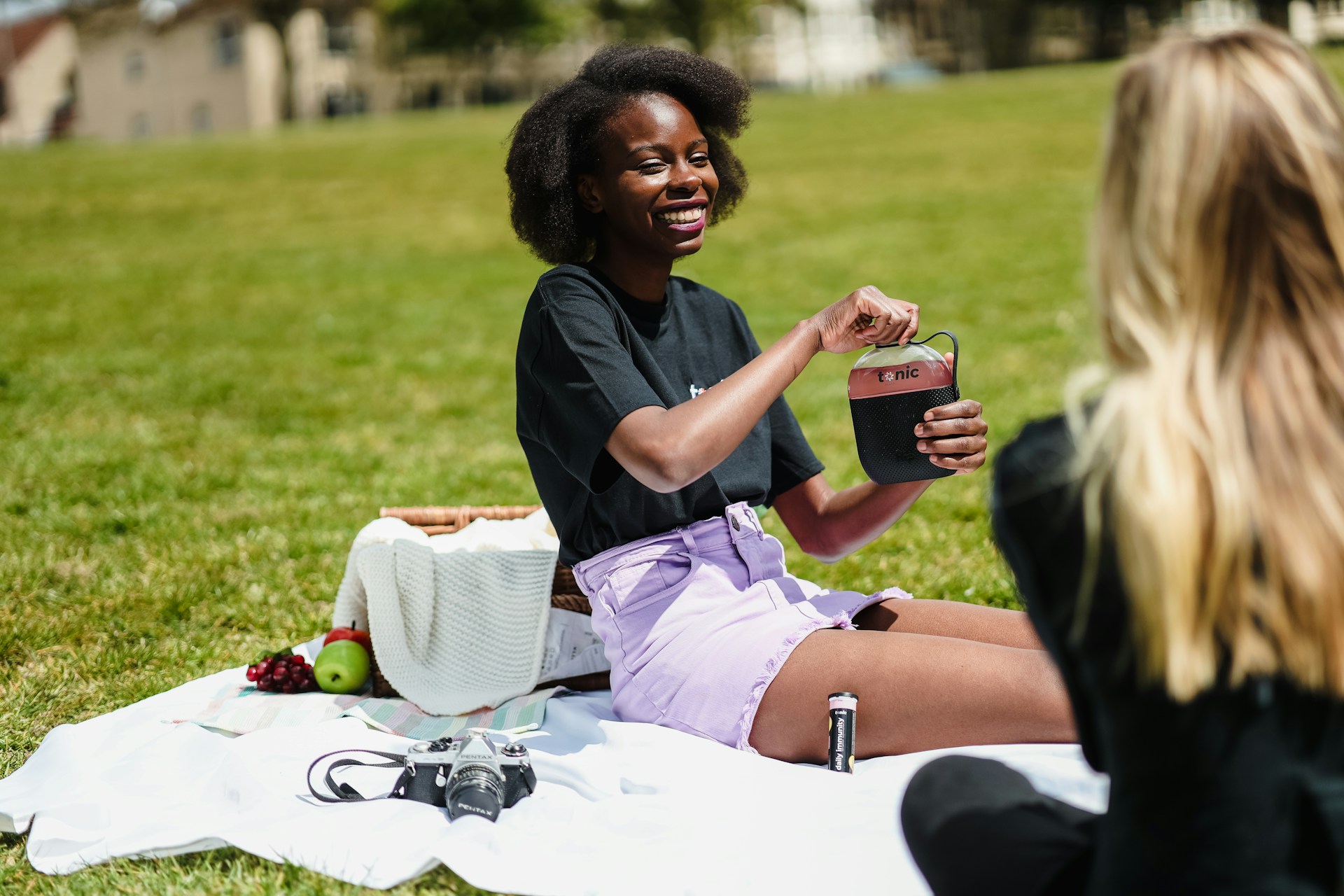 Two people seating with one person holding a water bottle