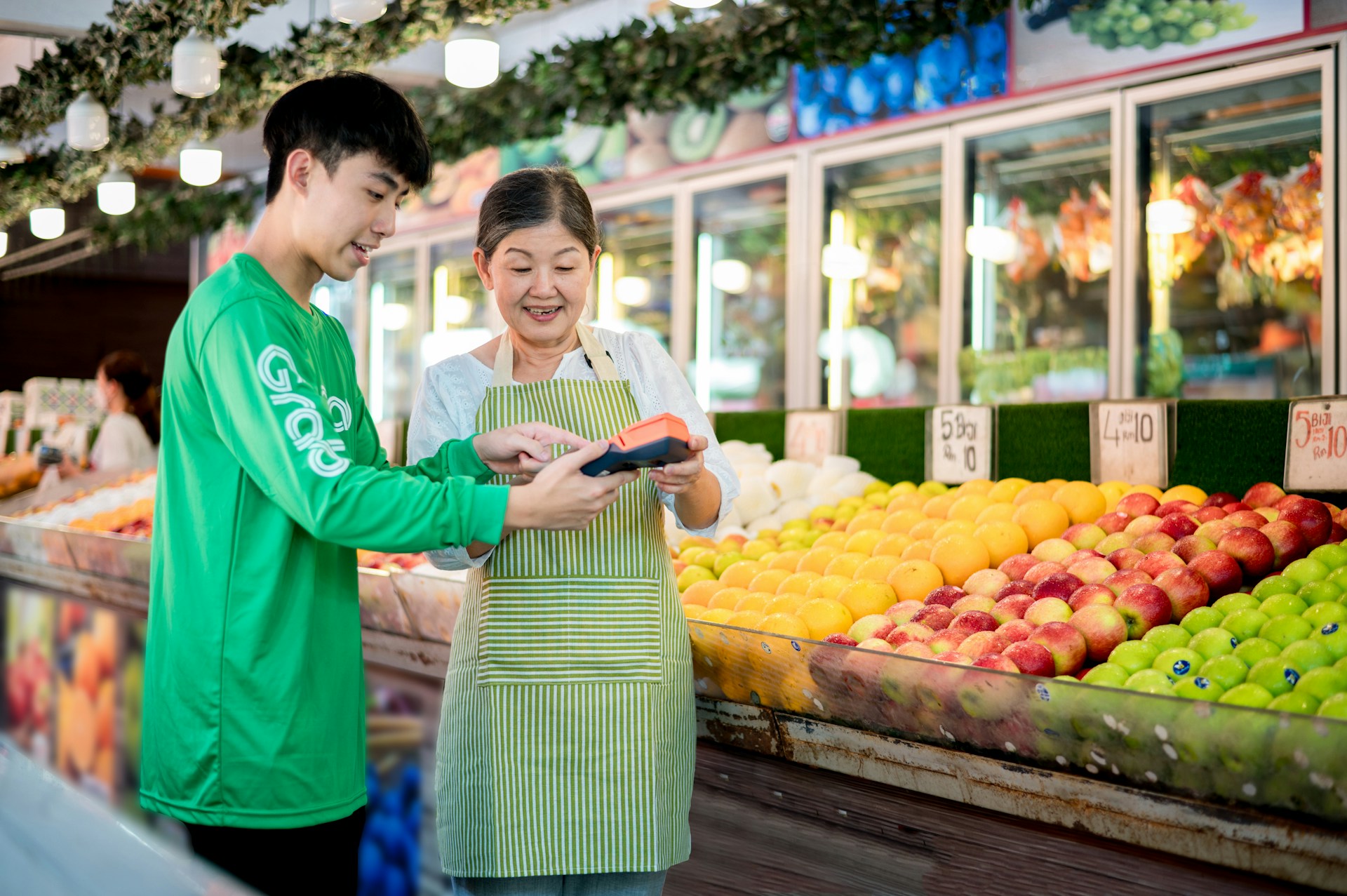 A man and a woman beside a Fruit aisle