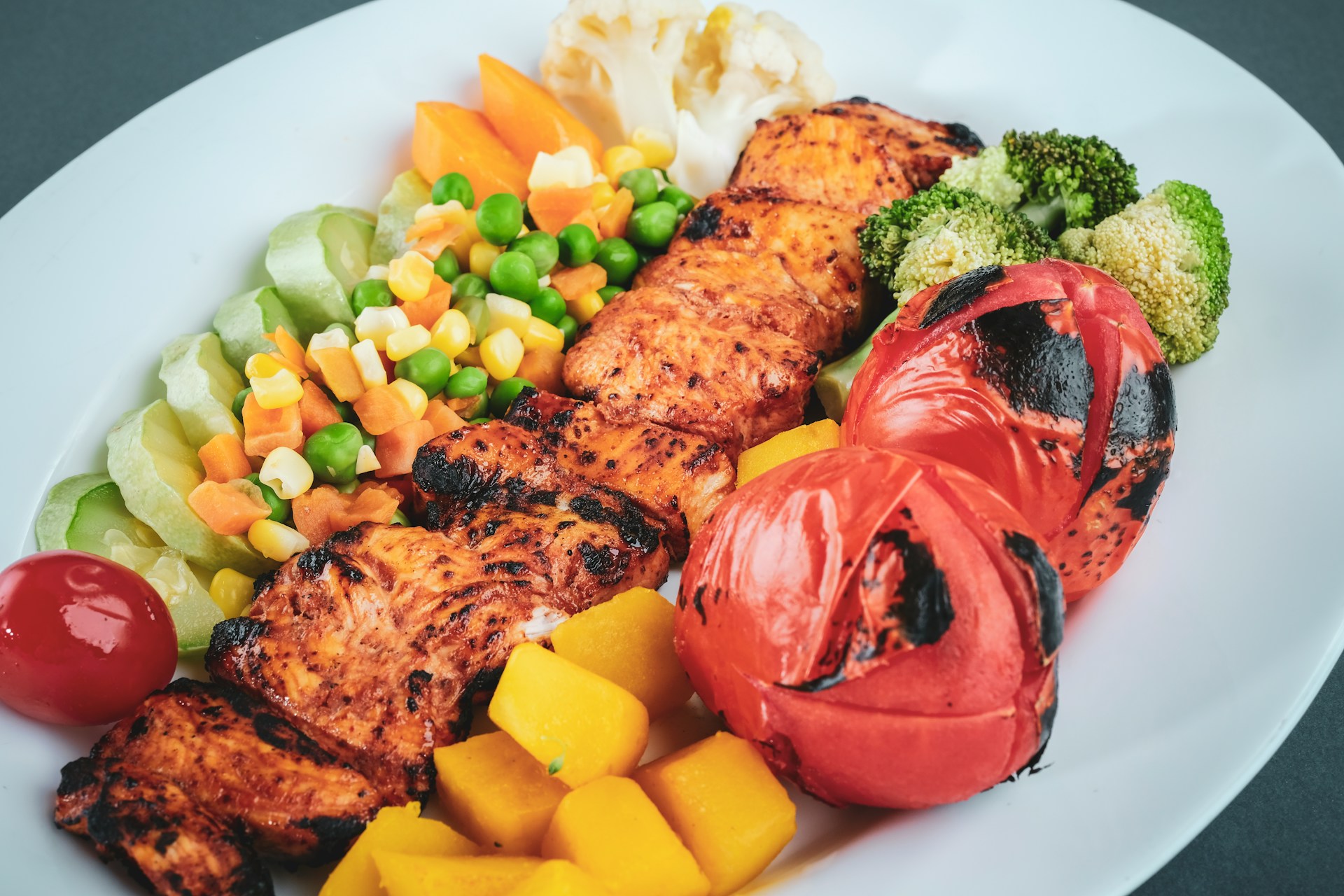 Steamed veggies and grilled fish on white ceramic