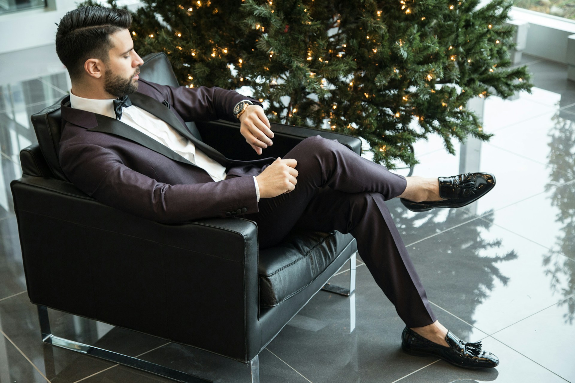 A man sitting and looking at his wrist watch